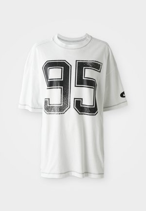 T-shirt blanc à manches courtes avec un grand numéro noir usé "95" sur le devant et un petit logo swoosh noir sur la manche gauche.