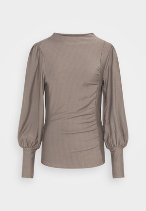 Bruine lange mouw top met opgezette mouwen, ronde hals, zijkant ruching en een gladde textuur. Het fabric heeft een lichte glans, zonder zichtbare patronen of accenten.