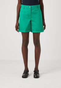 Grüne Shorts aus einem glatten Stoff mit tailliertem Schnitt, ausgestattet mit umgeschlagenem Saum, frontalen Taschen und einem einzigen Knopfverschluss.