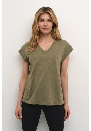 Maslinasto zelena v-nekl t-shirt izrađena od mekog, laganog materijala; ima kratke rukave i ležeran kroj. Kombinirana s crnim trapericama.