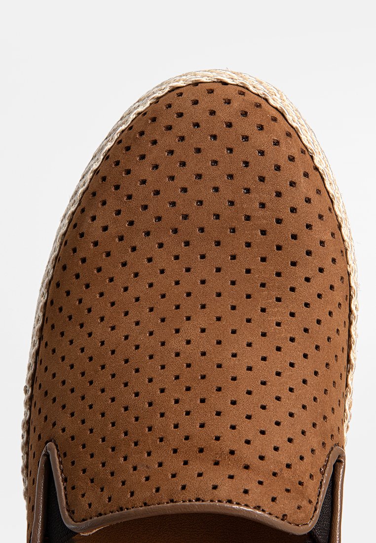 Braune Wildlederschuhe zum Hineinschlüpfen mit Perforationen zur Belüftung und einer gewebten Jutesohle, mit einem glatten schwarzen Innenfutter.