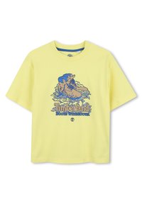 Gele katoenen t-shirt met een blauwe grafiek van laarzen en de tekst "Timberland Boots With Roots." Korte mouwen en een relaxte fit.