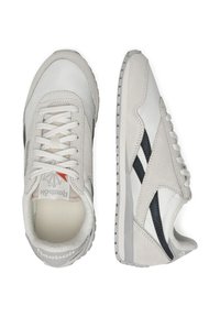 Białe sneakersy wykonane z gładkiej skóry i zamszu, z szarym podeszwy, kontrastującymi ciemnymi akcentami i tradycyjnymi sznurówkami.