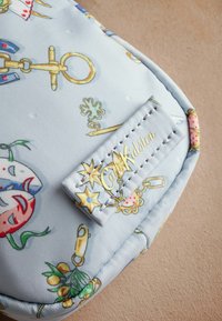 Ljust blå tygväska med färgglada, lekfulla mönster och gyllene detaljer. Inkluderar en tagg med "Cath Kidston" präglad i guld.