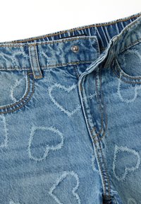 Lichtblauwe denim jeans met een hartjespatroon in een vervaagd design. Voorzien van een metalen knoopsluiting en zichtbare stikseldetails.