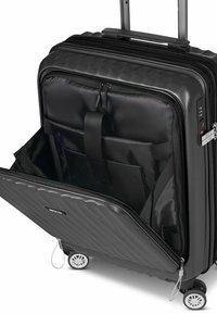 Valigia a mano nera con esterno rigato, doppie cerniere e molteplici tasche interne. Presenta una maniglia estensibile e ruote fluide.