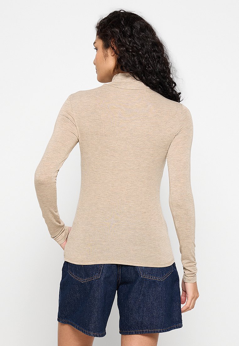 Beige Langarmoberteil mit hohem Kragen, aus weichem, leichtem Stoff, mit einer figurbetonten Passform und glatter Textur.