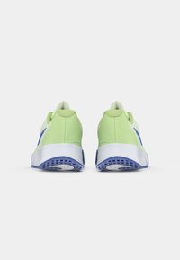 Ein Paar hellgrüne und blaue Tennisschuhe, von hinten gezeigt, mit weißen Zwischensohlen und gemusterten blauen Außensohlen auf einem weißen Hintergrund.