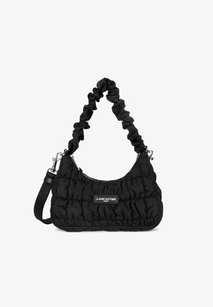 Sac à main matelassé noir avec une forme incurvée, une sangle froncée, des accessoires en argent et une étiquette de marque. Il possède une fermeture zippée et une sangle amovible.