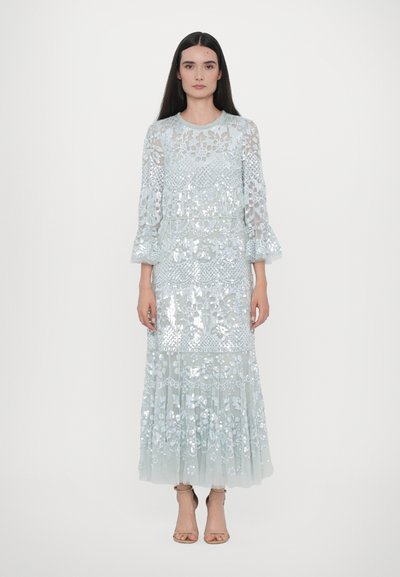 Light blue sequin-embroidered dress with long sheer sleeves, floral patterns, layered skirt, and ruffled hem. Sandals complete the look.