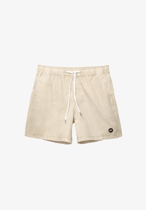 Beige fürdőnadrág rugalmas derékkal, fehér zsinórral, oldalsó zsebekkel és egy kis fekete logóval az alsó bal oldalon.