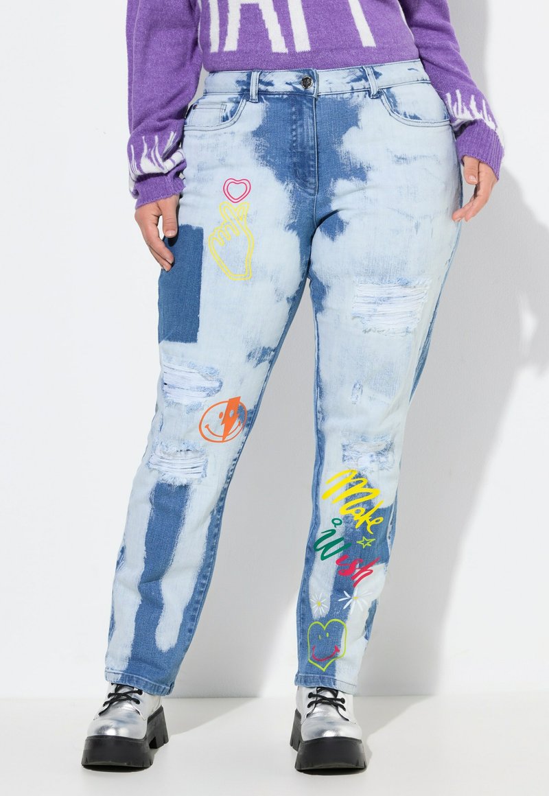 Svetle modré džíny z denimu se distressed nášivkami, barevnými vyšívanými vzory a unikátními motivy, obsahujícími několik grafických detailů a akcentů.