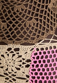Tessuto all'uncinetto con filati marroni, beige e rosa, caratterizzato da motivi geometrico-lace e motivi floreali, che mette in mostra textures e design vari.