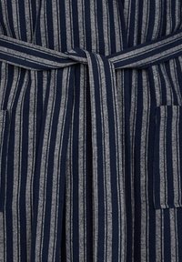 Marineblå og grå stribet morgenkåbe med bælte i stof, der har to frontlommer og en tekstureret overflade. Stropperne varierer i tykkelse.