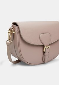 Borsa a tracolla rotonda realizzata in pelle texturizzata rosa chiaro. Presenta una chiusura a molla con una fibbia dorata e una tracolla staccabile.