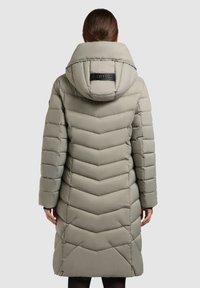 Vaaleanharmaa pitkähihainen toppatakki, jossa on siksak-kuvio, huppu ja takana oleva logoyksityiskohta. Sileä pinta ja suora leikkaus.