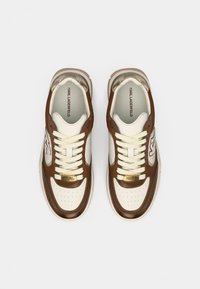 Καφέ και εκρού αθλητικά παπούτσια από δέρμα και σουέντ υλικά. Διαθέτουν διάτρητο μπροστινό μέρος, κορδόνια και χρυσές μεταλλικές λεπτομέρειες. Υφή στη γλώσσα και λογότυπο.