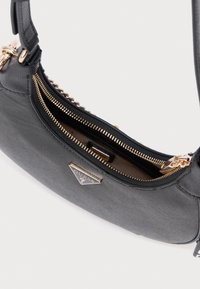 Szara teksturowana torebka z złotym zamkiem błyskawicznym, z logo na metce i gładkim paskiem. Wnętrze wyłożone podszewką, która uzupełnia zewnętrzny materiał.