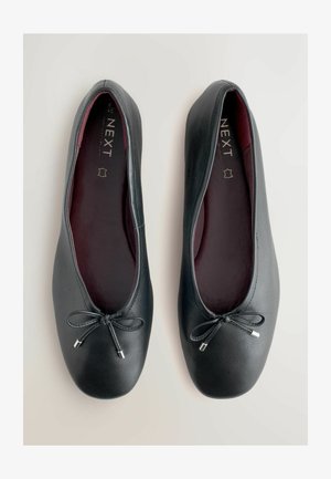 Černé baleríny z kůže s kulatou špičkou, zdobené černou mašlí a stříbrnými detaily, s burgundským vnitřním polstrováním.