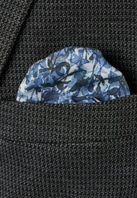 Grau texturiertes Gewebe mit einer blumigen Taschentuch in verschiedenen Blautönen, das aus einer Sakkotasche hervorlugt und feine Muster sowie weiche Materialien hervorhebt.