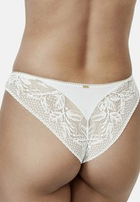 Witte kanten string met bloemenpatroon en mesh accenten, met een gladde voorpaneel en fijne stiksels langs de randen. Gouden hardware detail.