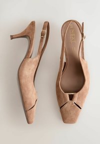 Zapatos de tacón en ante color marrón claro con punta afilada, diseño con cortes y una hebilla metálica. Cuentan con un tacón delgado de 7.5 cm y una plantilla suave.