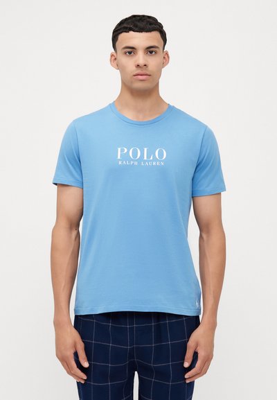 Jasnoniebieska bawełniana koszulka z krótkim rękawem i okrągłym dekoltem. Z przodu znajduje się biały nadruk z logo "POLO RALPH LAUREN".