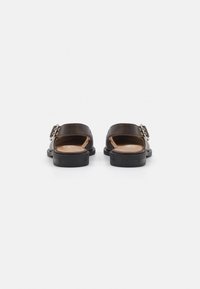 Dark brown leather slide sandals with an open back, featuring a metallic buckle accent and a flat black sole.