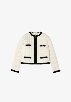 Jachetă albă matlasată cu mâneci lungi, având margini negre de-a lungul gulerului, în față, la manșete, tiv și patru buzunare frontale cu nasturi și margini negre.