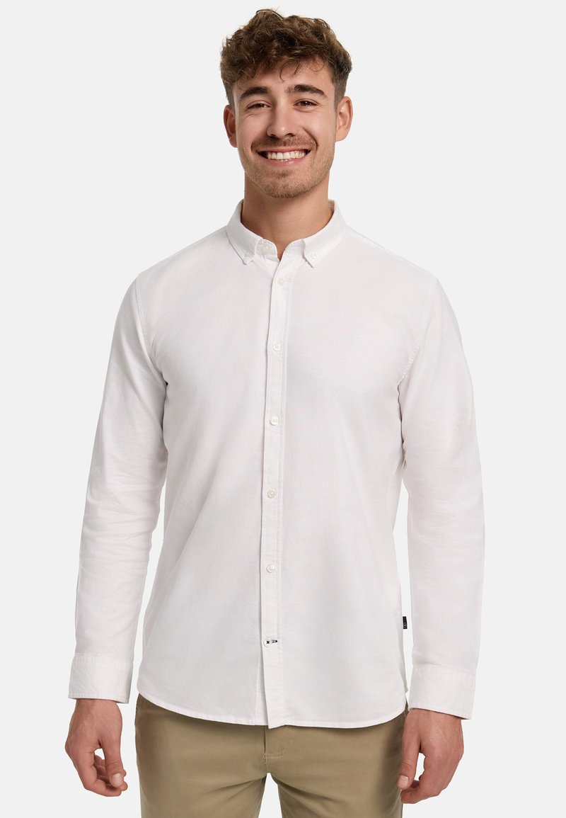 Witte blouse met lange mouwen en een button-down kraag, met een gestructureerde stof en knopen aan de voorkant, gecombineerd met lichtbeige broek.
