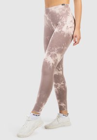 Strakke, hooggeknoopte legging in een roze en beige tie-dye patroon, gemaakt van een gladde, rekbare stof. Heeft een brede tailleband voor comfort.