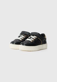 Sneakers neri e glitterati con lacci bianchi, chiusura a strap, dettagli dorati e una spessa suola bianca. Superfici lisce e testurizzate.