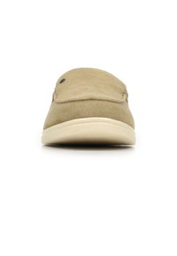 Zapato de ante beige sin cordones con punta redonda, superficie lisa y suela de color claro en contraste. Presenta costuras decorativas y un pequeño detalle de hardware.