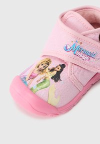 Rožinė audinio avalynė su guminėmis padangomis, ant kurių pavaizduota undinės tema ir „Mermaid Magic“ tekstas mėlyna spalva. Velcro dirželis, kad būtų lengviau užsidėti.