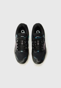 Scarpe da ginnastica nere con tomaia in mesh testurizzata, dettagli rosa e blu, e suola in gomma robusta. Presentano chiusura con lacci e colletto imbottito.