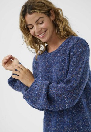 Blue knitted sweater with textured yarn, featuring a wide cuff and crew neckline. The fabric has multicolored flecks throughout, adding depth.