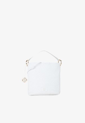 Witte geweven leren handtas met korte handgreep, decoratieve kwast en klein gouden embleem aan de voorkant tegen een witte achtergrond.