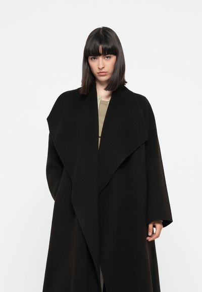 Mustat suuret takit, joissa on leveä kaulus, valmistettu pehmeästä materiaalista, joka on drapeerattu muotoilu ja ilman näkyviä kiinnityksiä. Elegantti siluetti.