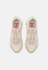 Beżowe buty sportowe z siateczkową cholewką, gumową podeszwą, okrągłym noskiem i teksturowanymi akcentami. Posiadają kontrastujące sznurowadła oraz logo na języku.