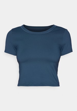 T-shirt court bleu marine en tissu doux et extensible. Présente un col rond et des manches courtes avec de simples détails de couture.