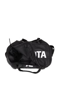 Sac de sport noir en matériau durable, avec un grand compartiment, une poche en mesh, des poignées latérales et un logo blanc bien visible.
