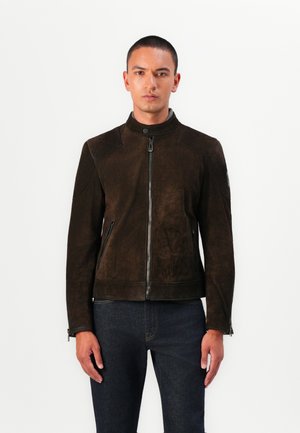 Chaqueta de ante marrón con cuello alto, cierre frontal de cremallera y bolsillos laterales; cuenta con una tela texturizada y un diseño ajustado.