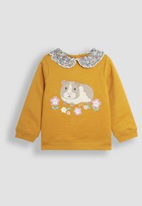 Maglione giallo senape con maniche lunghe, colletto a ruffle con motivo floreale e una grafica di un porcellino d'India circondato da fiori rosa e blu.