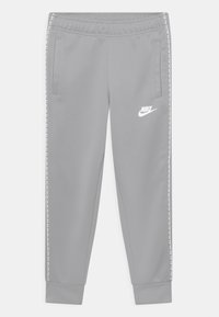 Light gray Nike track pants with side stripe detailing, elastic waistband, zippered pockets, and cuffed ankles.