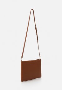 Brun läder crossbody-väska med en slät yta, rektangulär form, justerbar rem och dragkedjestängning upptill. Har silverfärgade detaljer.