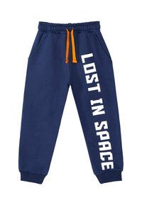 Pantalones de chándal azul marino con cordón naranja, cinturilla elástica y puños, bolsillos frontales y texto blanco "PERDIDO EN EL ESPACIO" en la pierna derecha.
