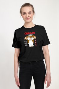 Sort bomulds-T-shirt med et farverigt Gremlins-grafik, tekst og tre regler illustreret med tegneseriestilbilleder.