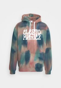 Mikina s kapucí s tie-dye vzorem v odstínech tyrkysové, hnědé a růžové, s přední kapsou a bílým grafickým textem "CLETO MANIX" na hrudi.