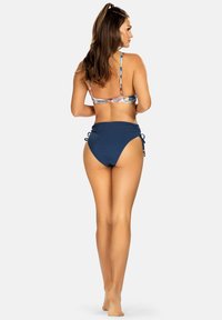 Zestaw bikini z wzorzystym stanikiem i regulowanymi ramiączkami, oraz jednolitym, granatowym dołem o wysokim stanu z bocznymi zawiązaniami. Gładka faktura materiału.