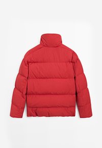 Rote Steppjacke mit hohem Kragen, gesteppter Optik und kastiger Form mit horizontalen Nähten zur Isolierung. Glatte Stoffstruktur.